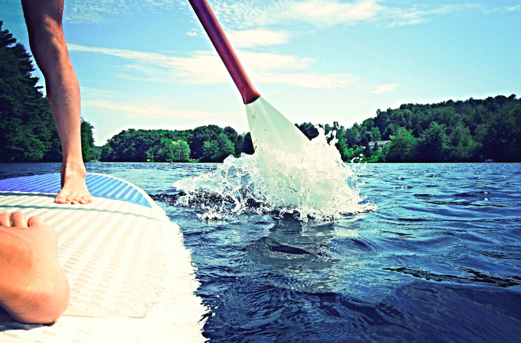 Two figures standing on a paddleboard.