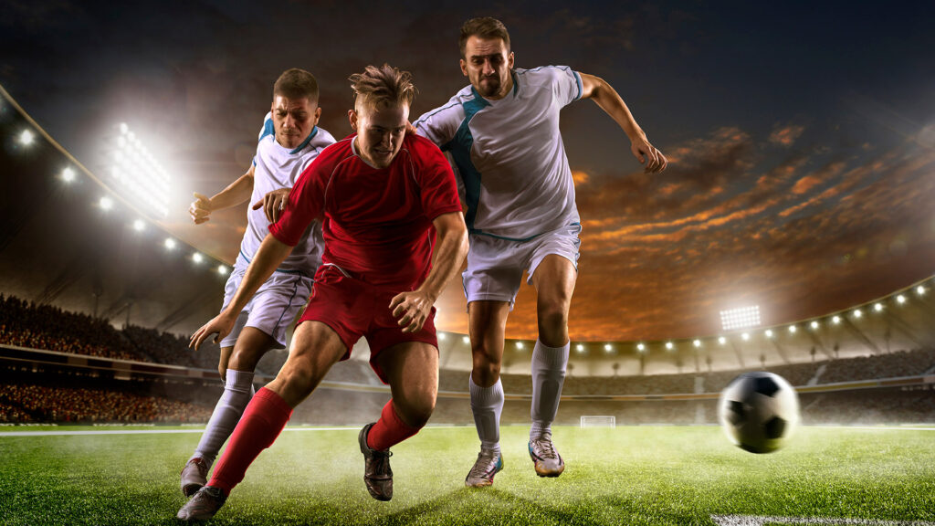 Soccer players in action on the sunset stadium background panorama