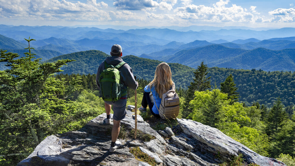 Couple on top of the mountain enjoying beautiful view. Blue Ridge Mountains, near Asheville, North Carolina.USA.