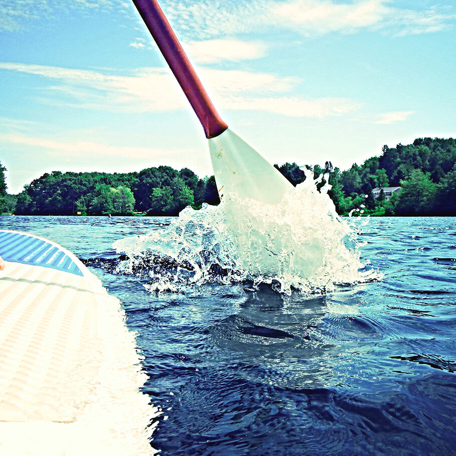 Two figures standing on a paddleboard.