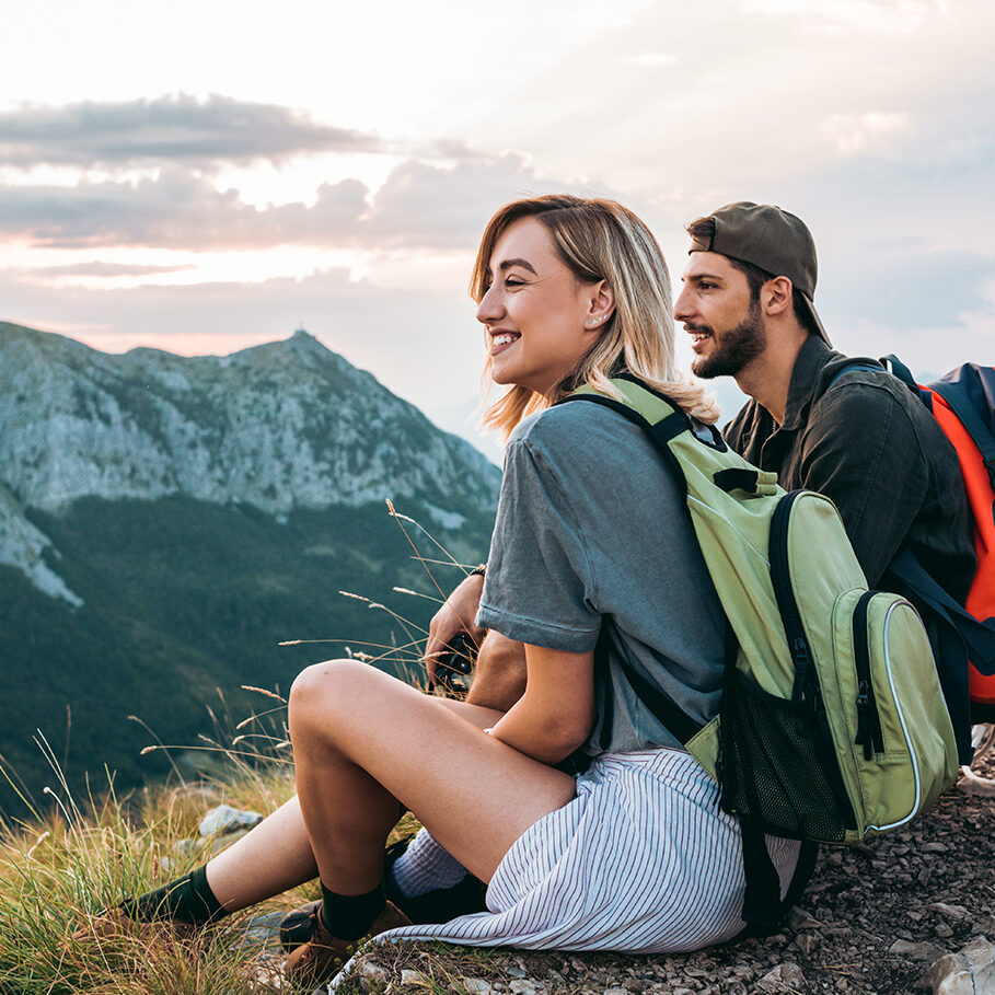 young couple of hikers enjoying the beautiful nature from high above