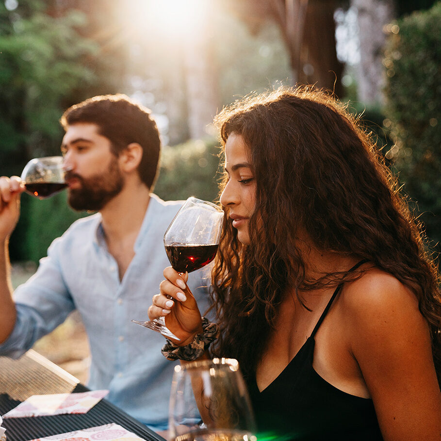 People are having a wine tasting experience at the farmhouse. Sunset time. Friends on vacation together.