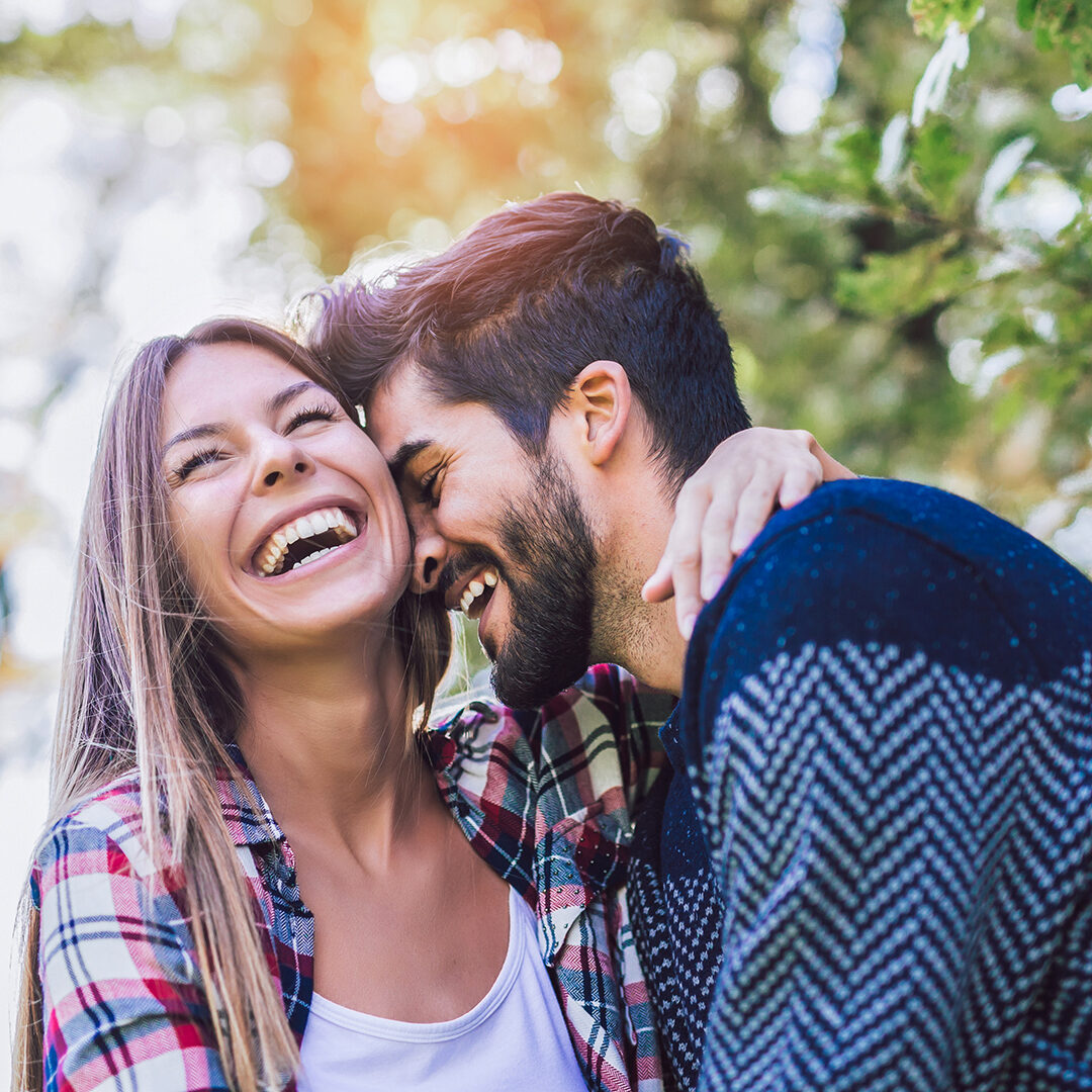 Happy couple in love having fun outdoors and smiling.