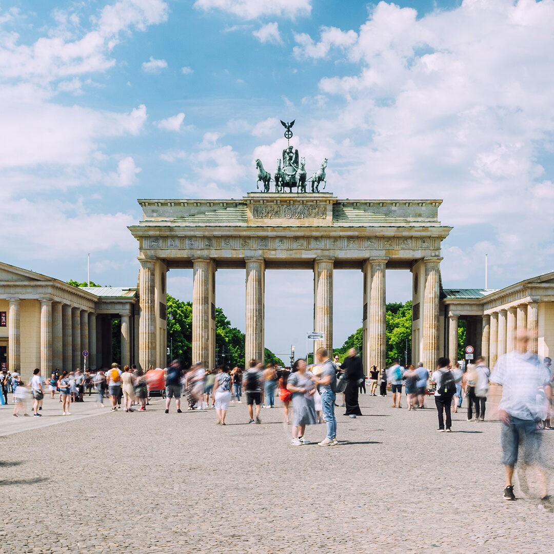 Dynamic crowd, Brandenburg Gate, Berlin, daytime, bustling city, blurred motion, lively atmosphere.
Berlin, Germany