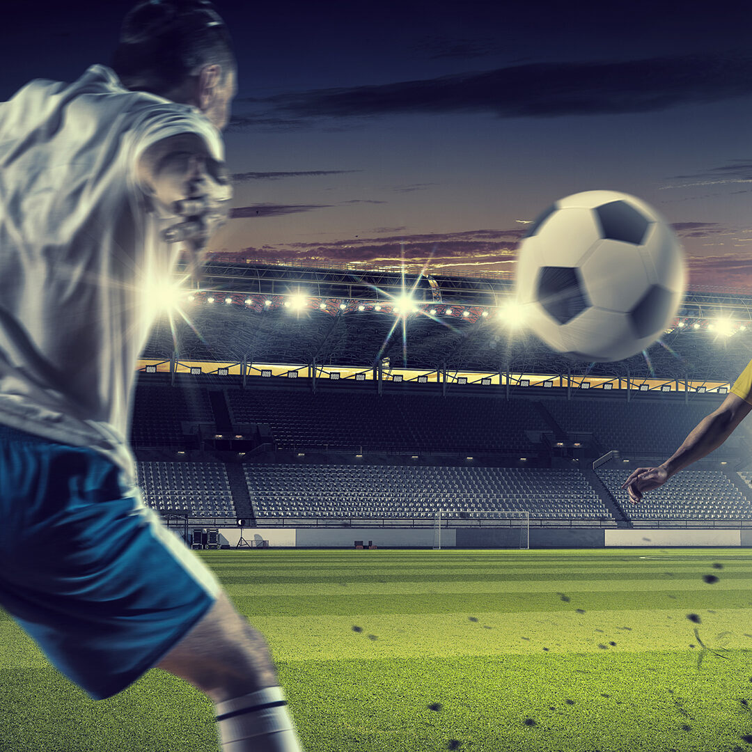 Football players at stadium field fighting for ball