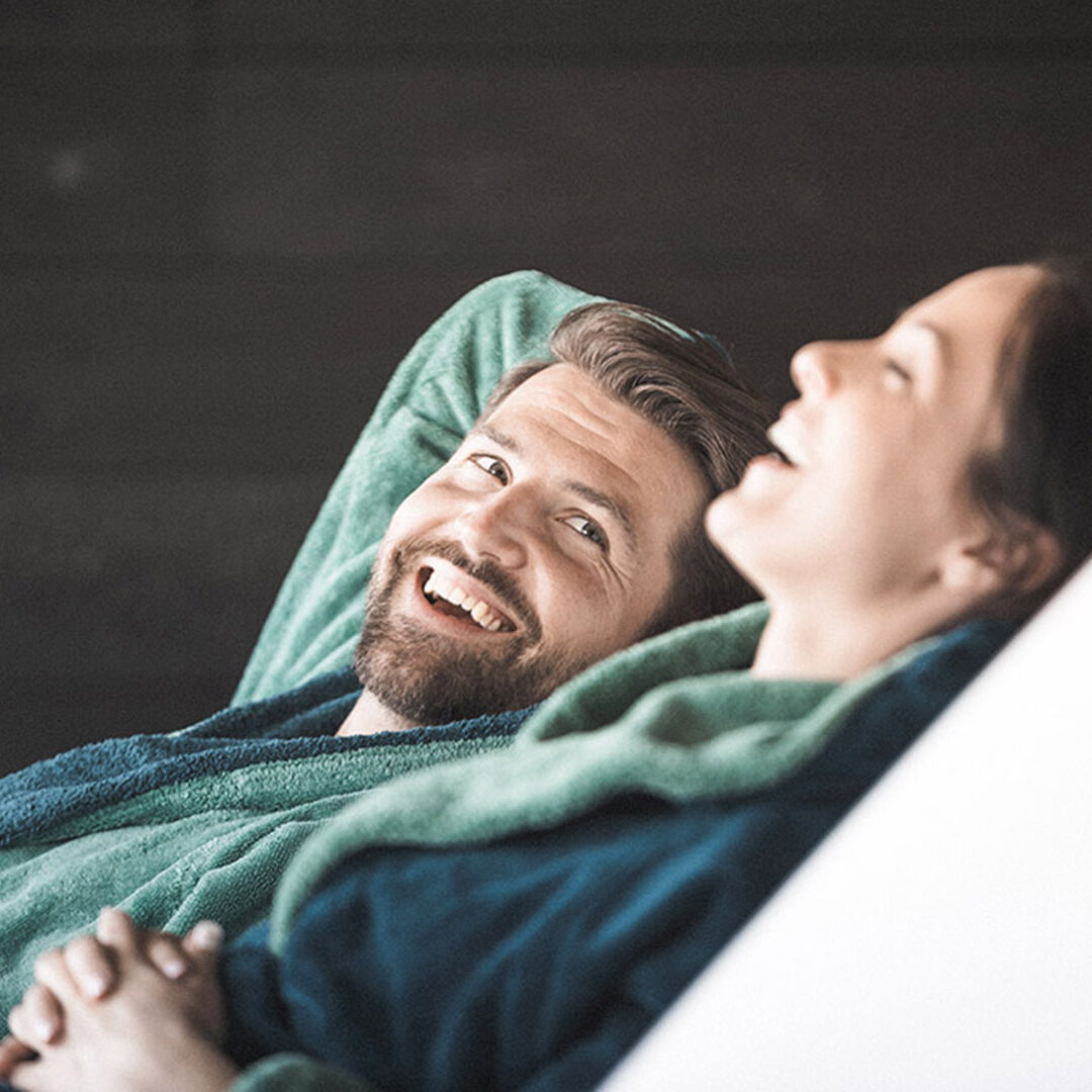 A couple sitting on lounge chairs in a wellness hotel. They are relaxing.