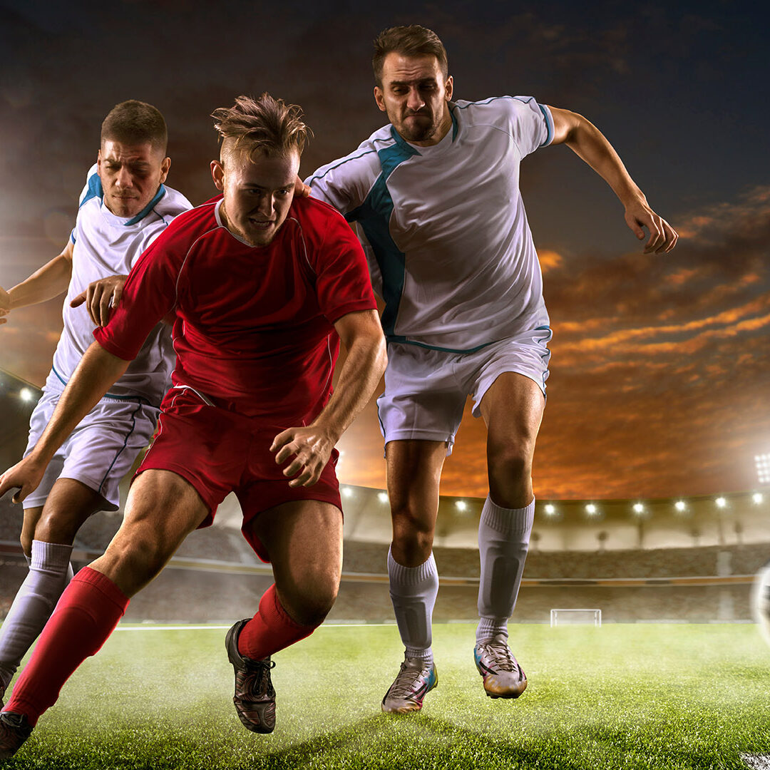 Soccer players in action on the sunset stadium background panorama