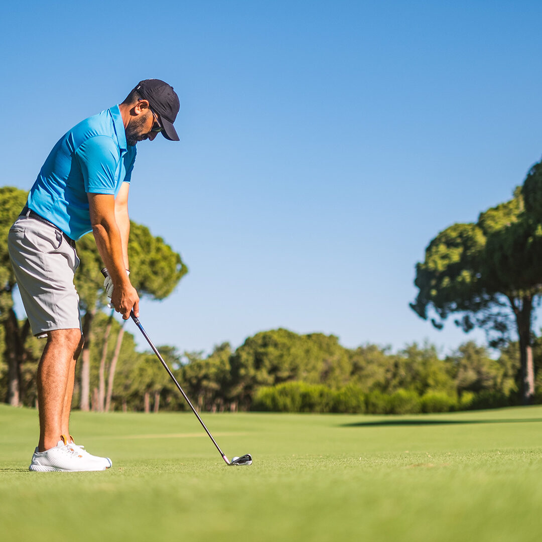 Man playing golf on field.